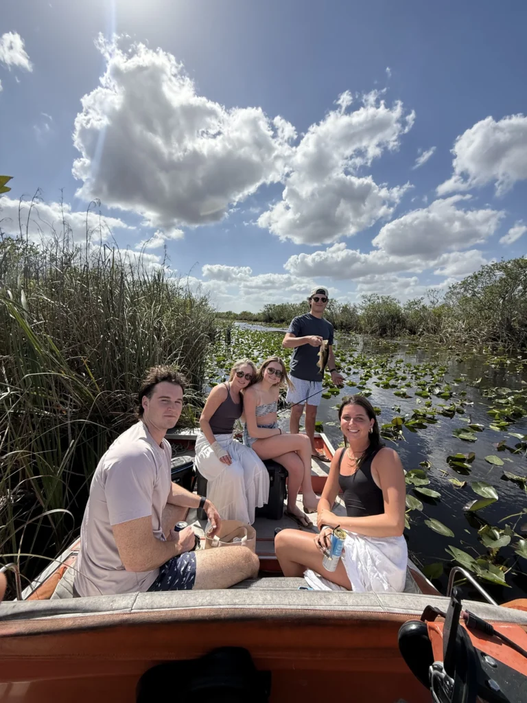 Guests relaxing on a private airboat under a bright Everglades sky