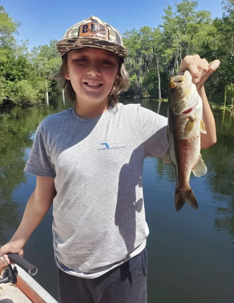 Young angler holding a largemouth bass caught in the Everglades