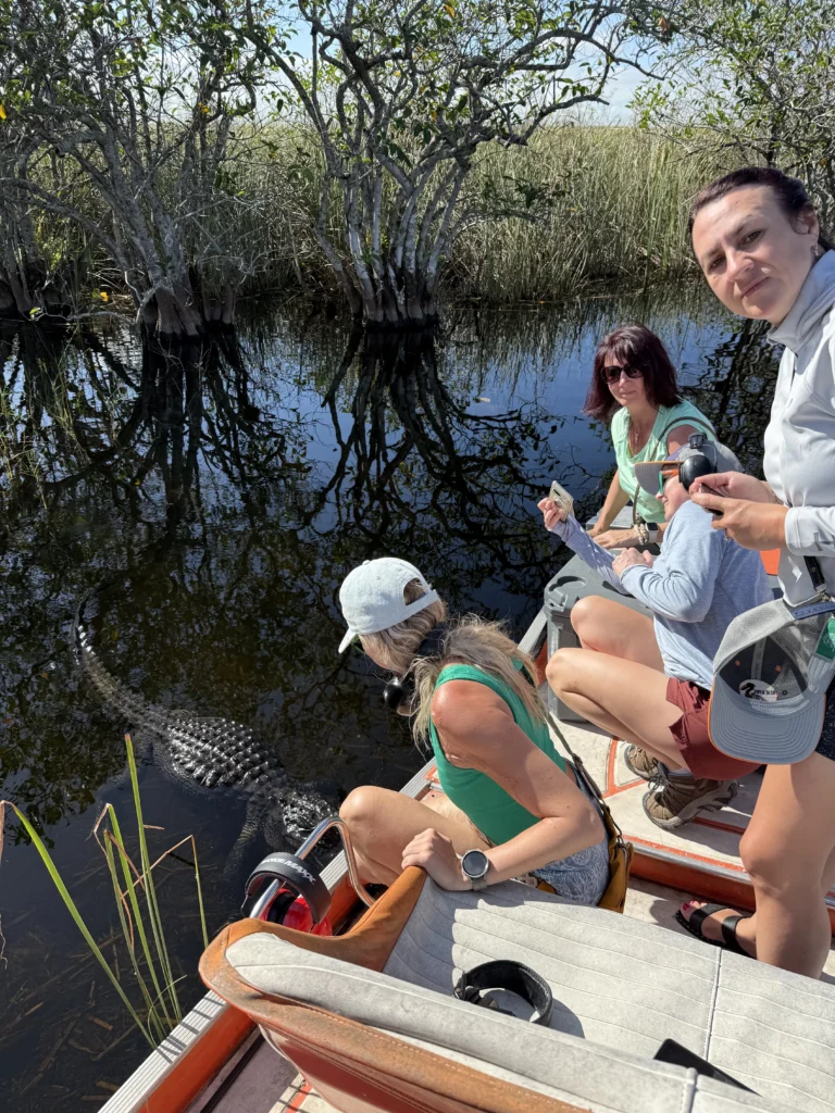 Guests taking a selfie on a private airboat in a mangrove-lined Everglades channel