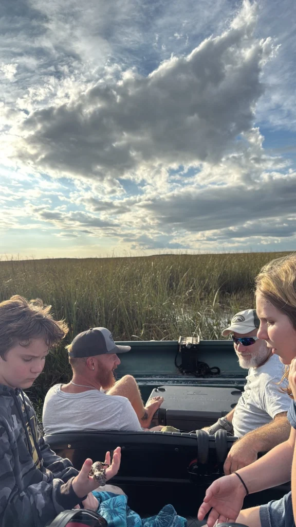 Guests riding a private airboat under big Everglades clouds