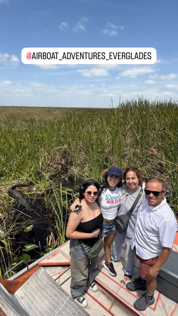 Family posing on a private airboat in the Everglades sawgrass
