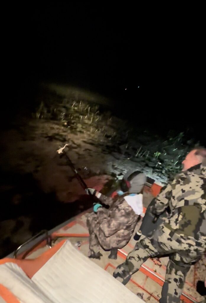 Guests frog gigging from an airboat at night