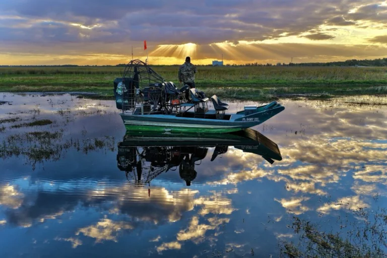 Airboat reflected in the water at sunset